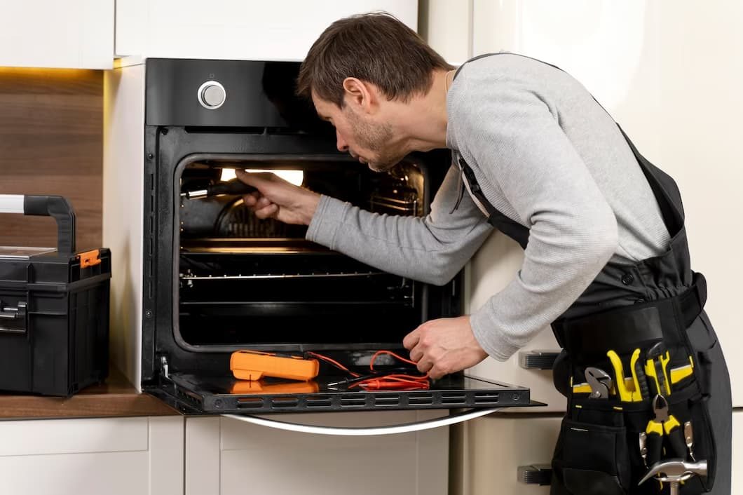 Technician repairing a built-in oven